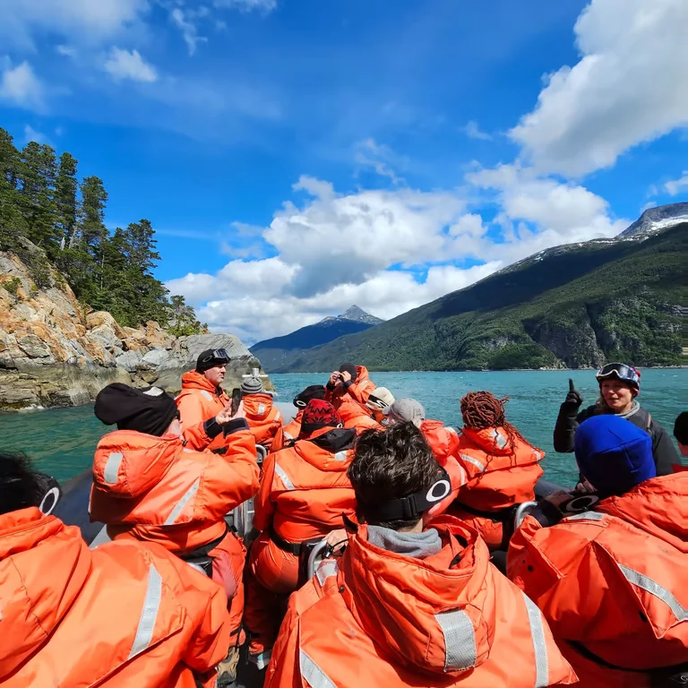 An expedition boat in a mountain-lined Alaskan waterway