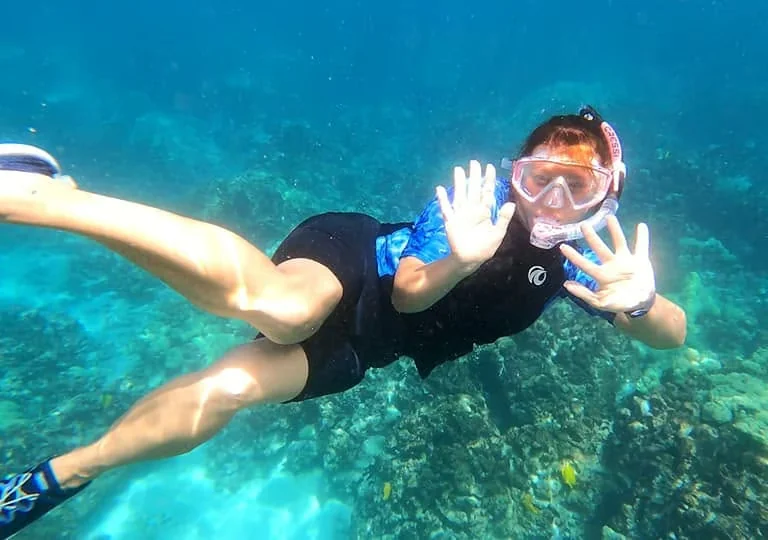 Gloria snorkeling above a coral reef in Kona