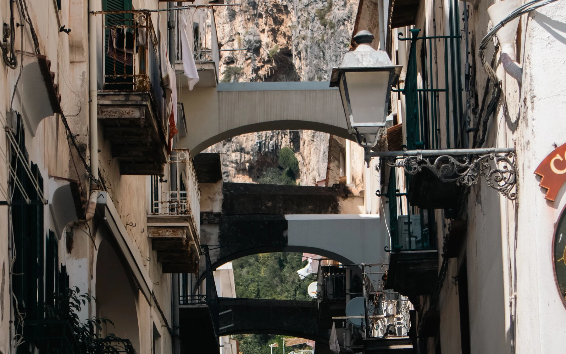 Arches, balconies and a street lantern above a narrow lane in Positano