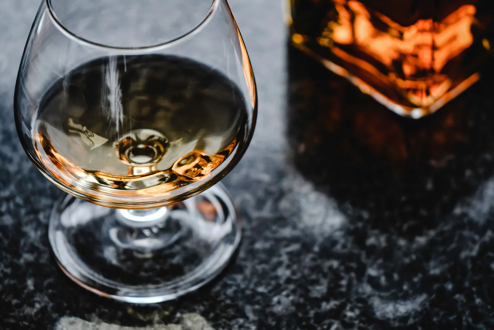 A tasting glass and a decanter of amber-colored spirits