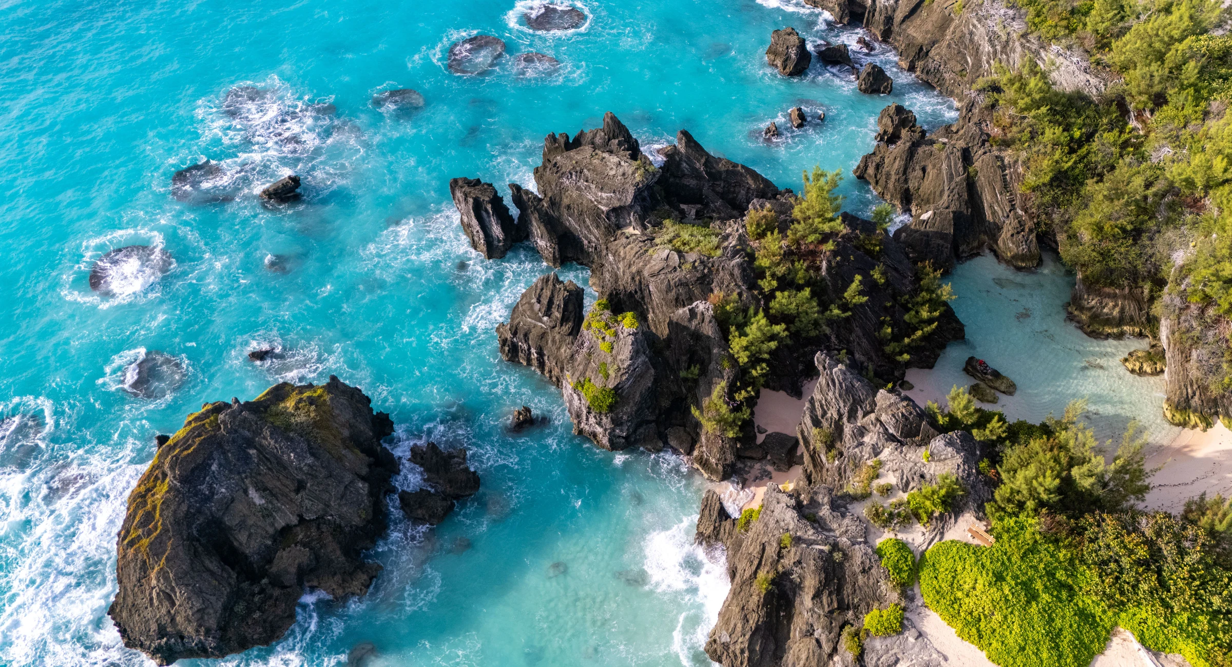 Turquoise waves around rocky coves and small sandy beaches