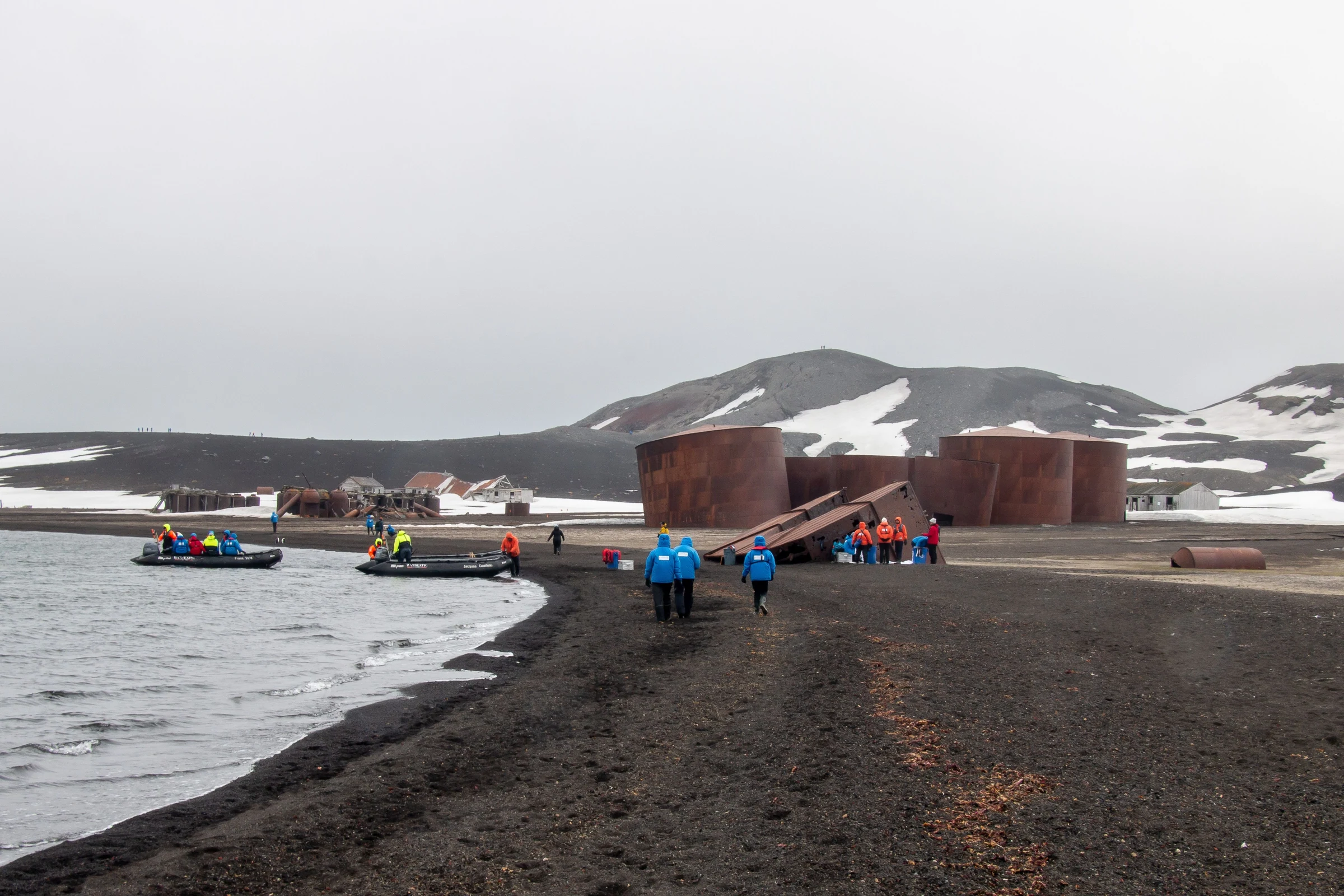 Historic whaling tanks and expedition visitors at Whalers Bay, Deception Island