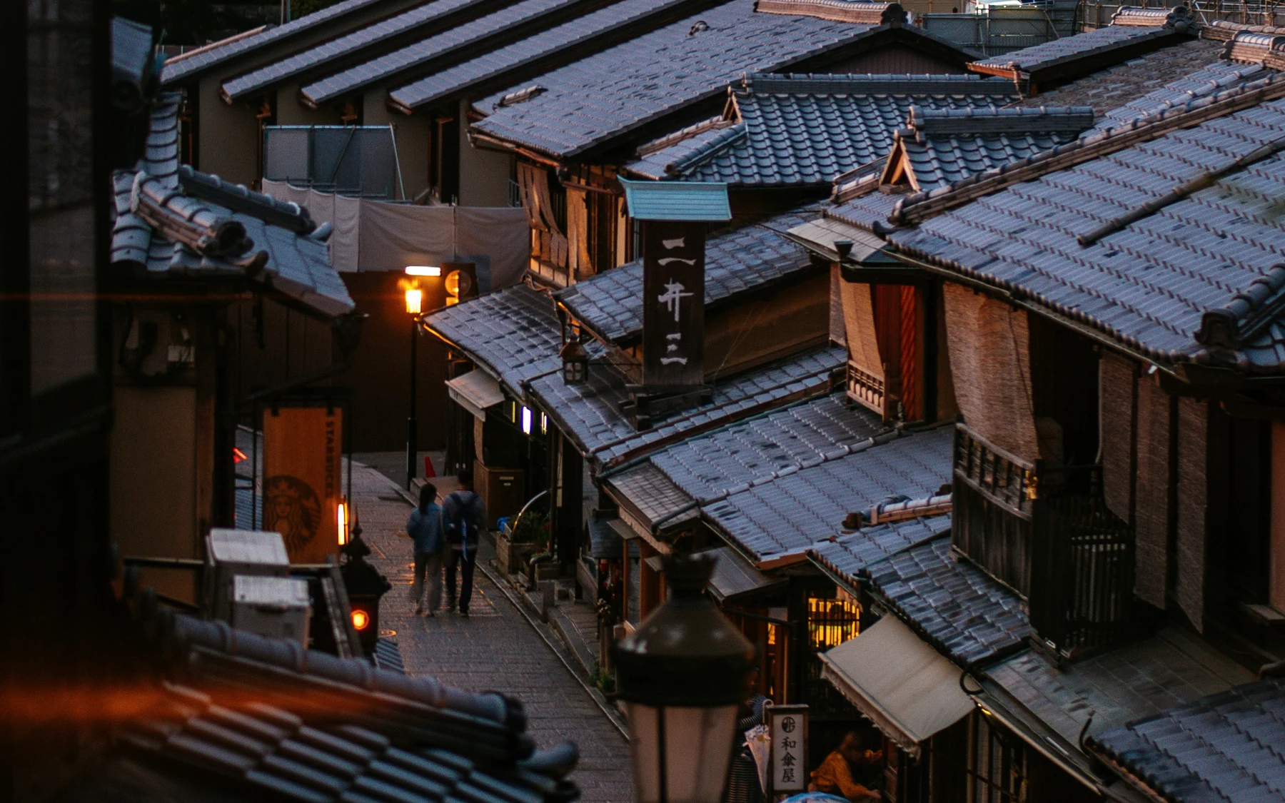 Lanterns and traditional wooden buildings along a lane in Gion, Kyoto