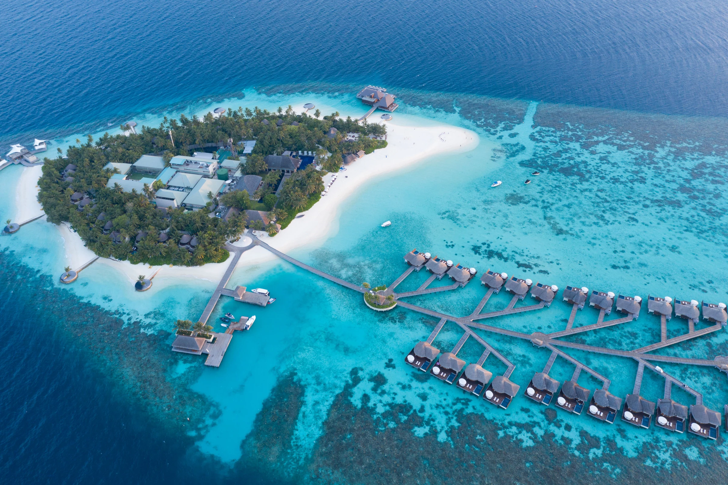 Aerial view of a tropical island resort, white sand and overwater villas