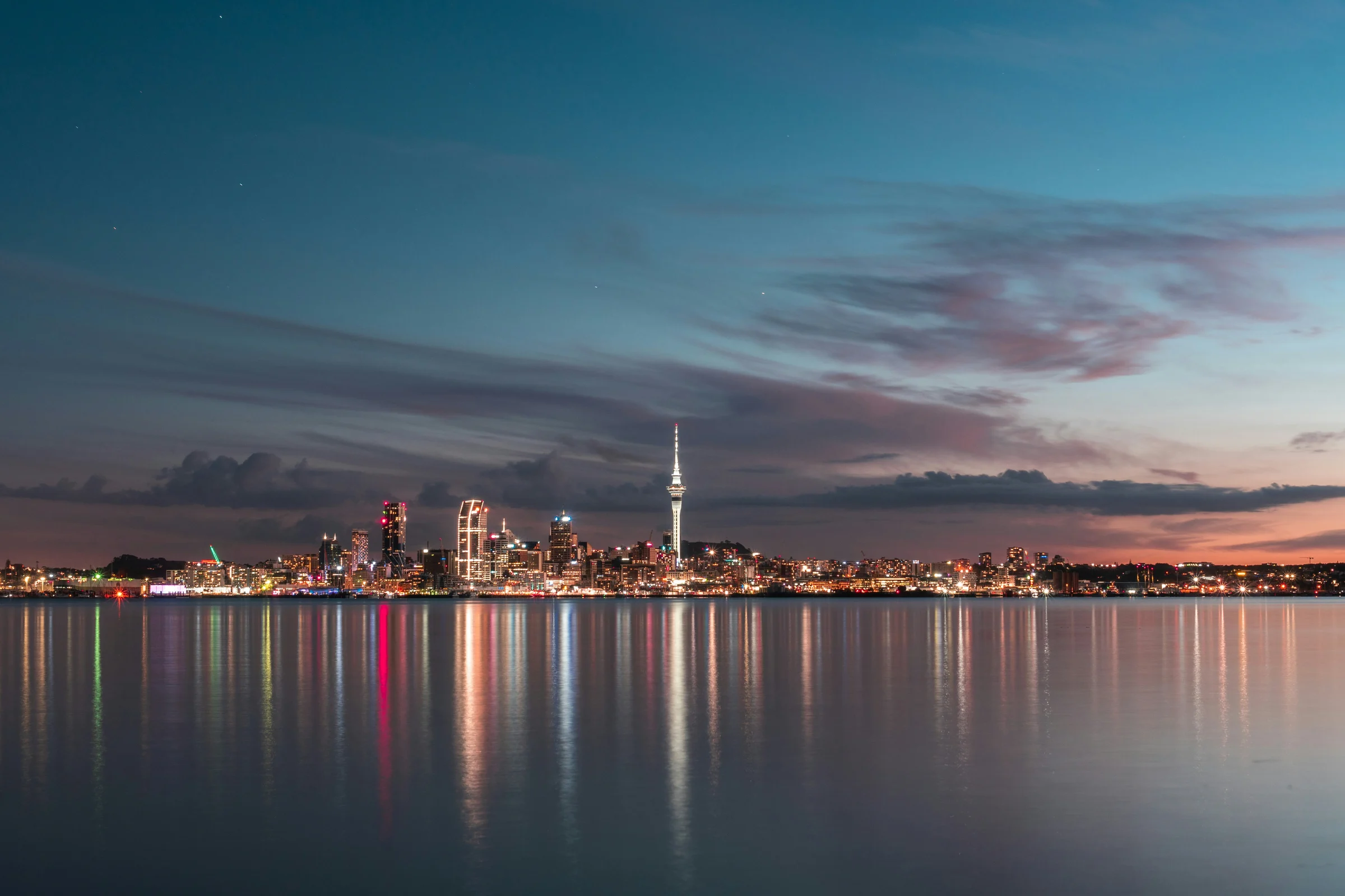 Auckland skyline and Sky Tower reflected in the harbour at dusk