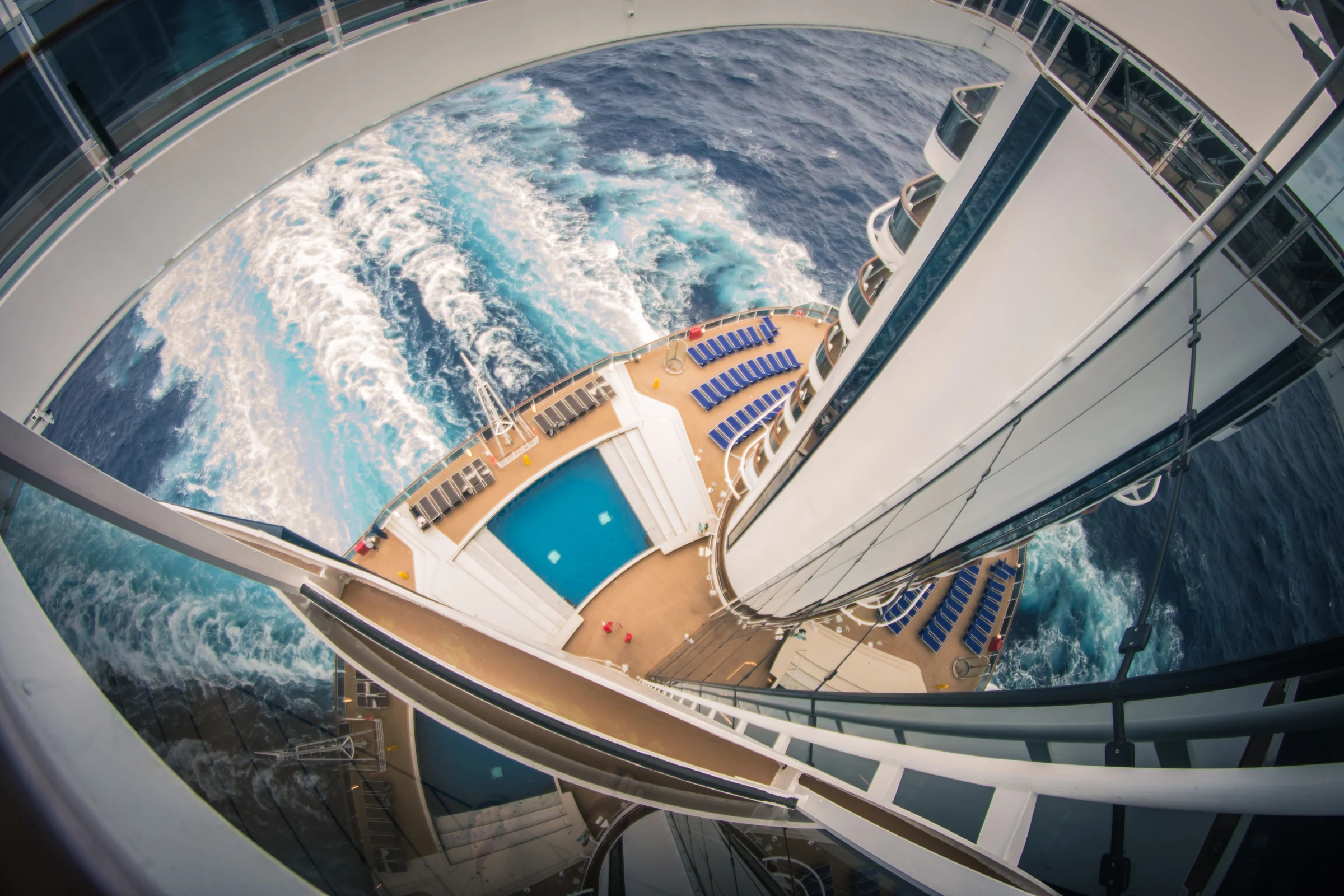 View down a cruise ship toward the pool deck and ocean wake