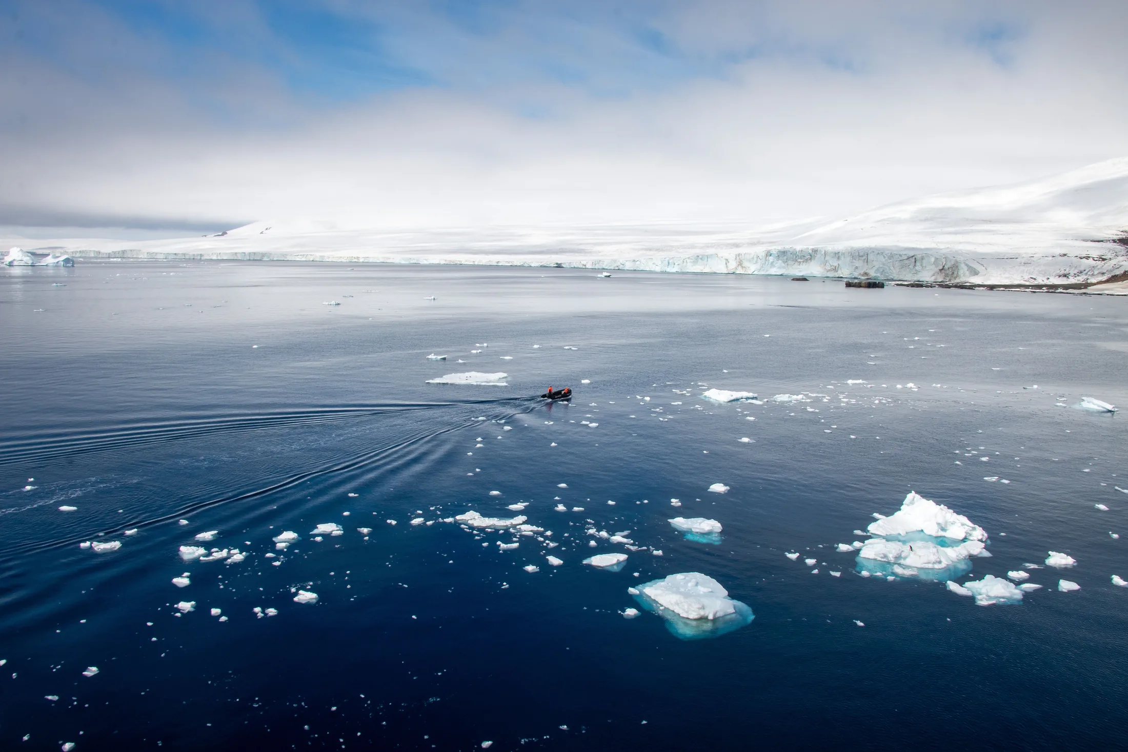 Floating ice beneath snow-covered mountains