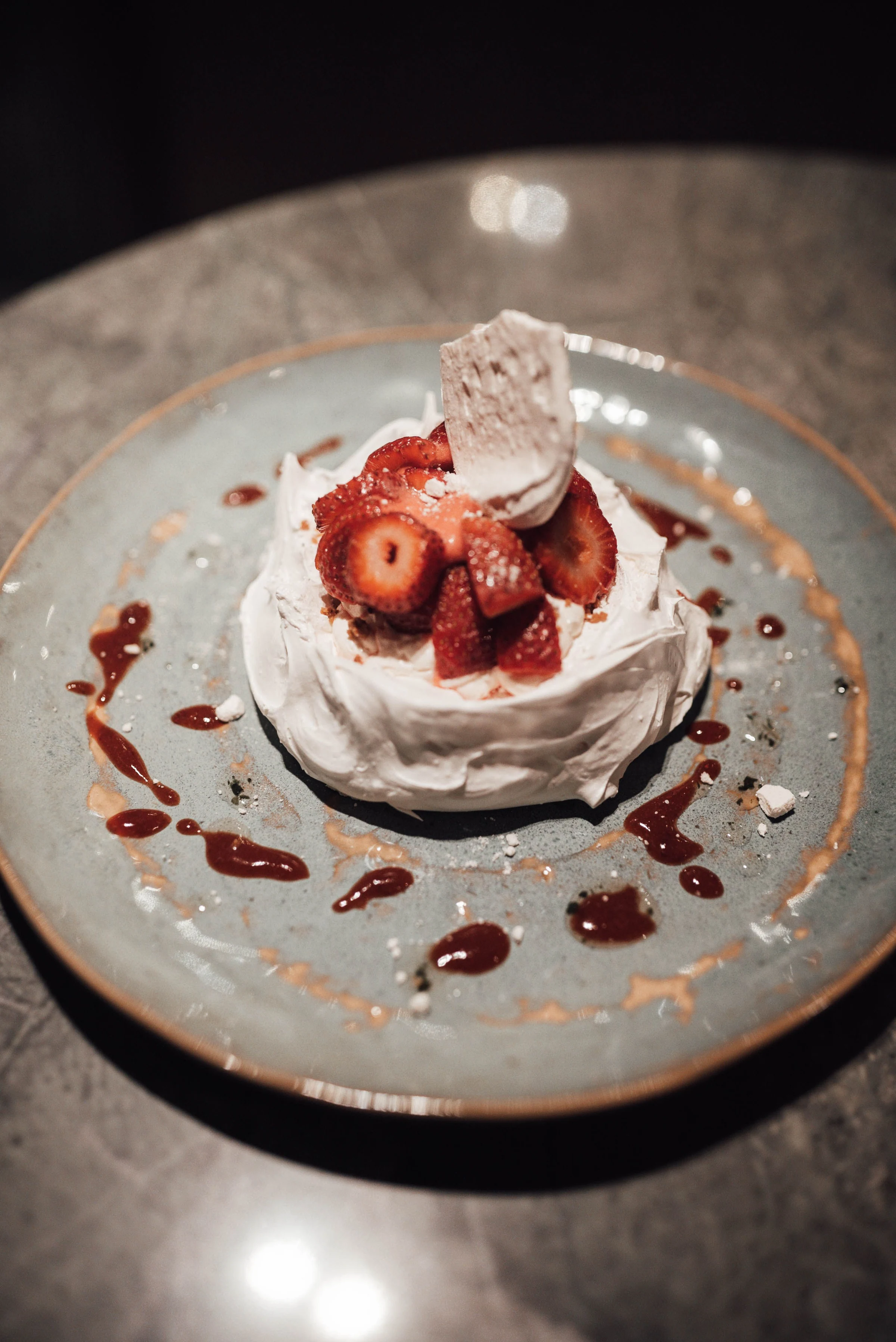Strawberries and cream on a plated meringue dessert