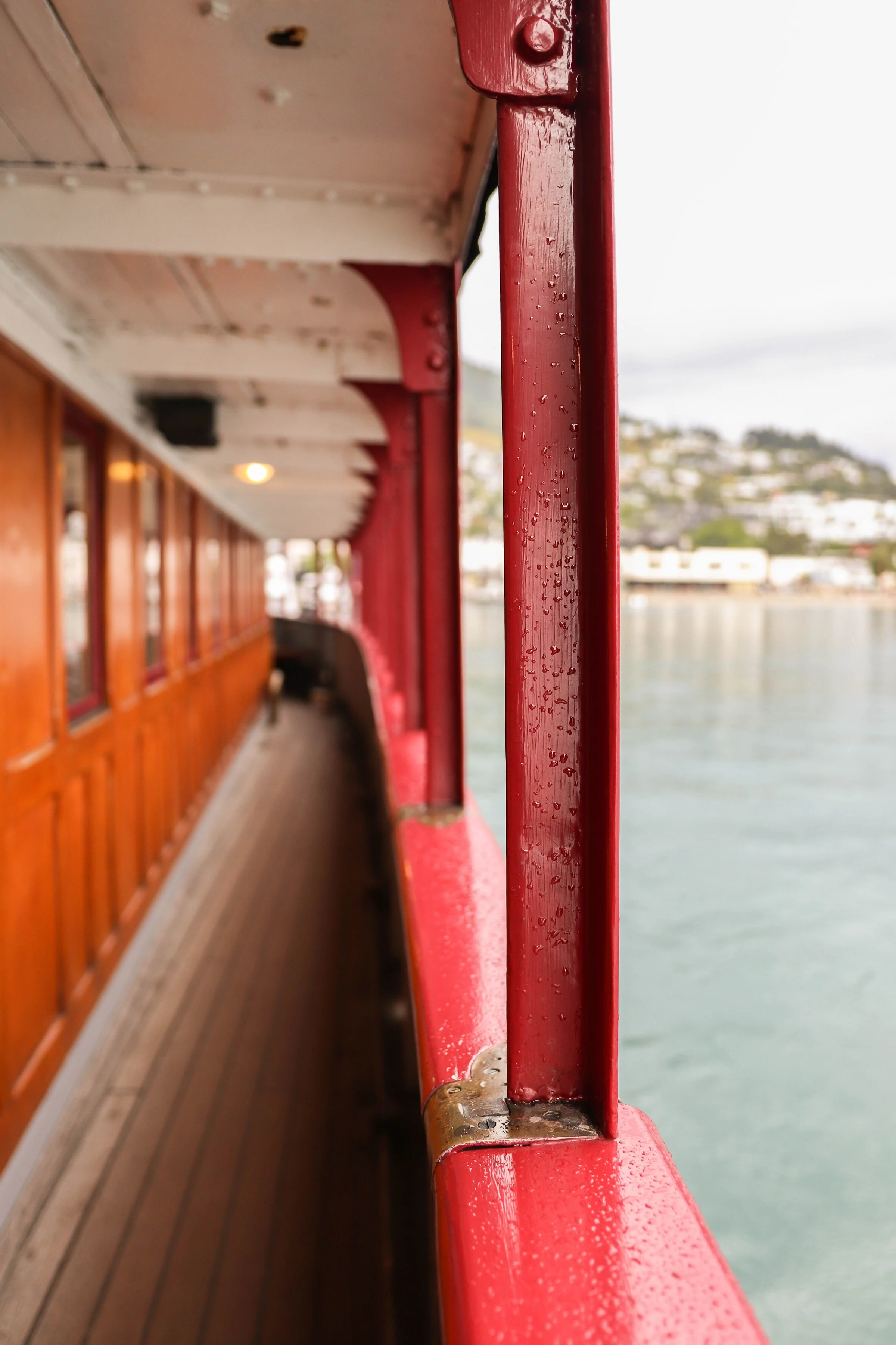 Red-painted pillars and a wooden passenger deck beside a lake