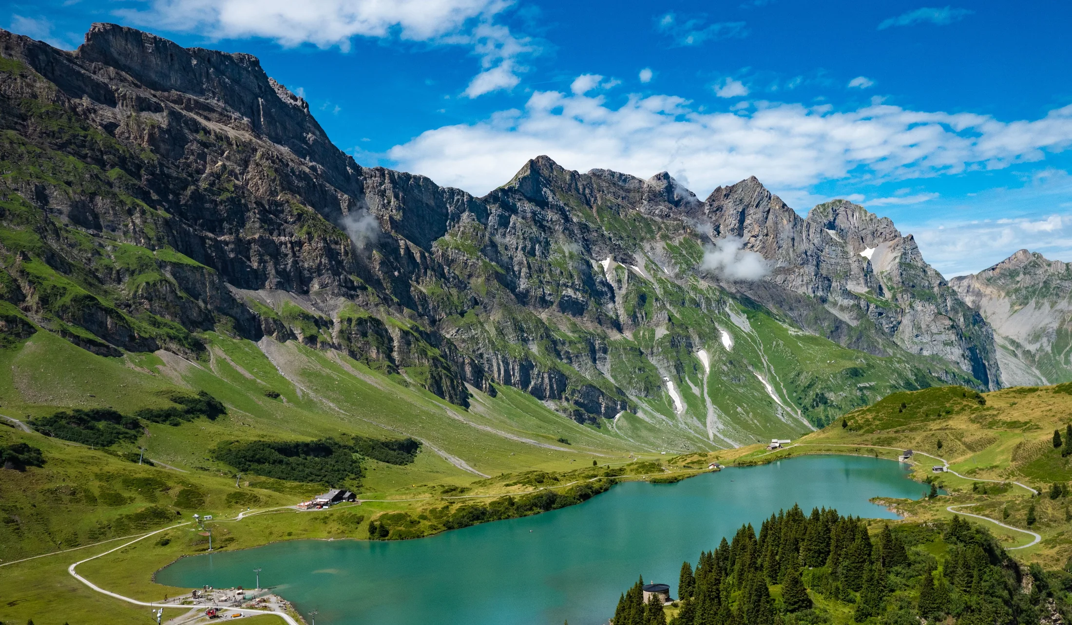 Green alpine slopes surrounding a mountain lake in Switzerland