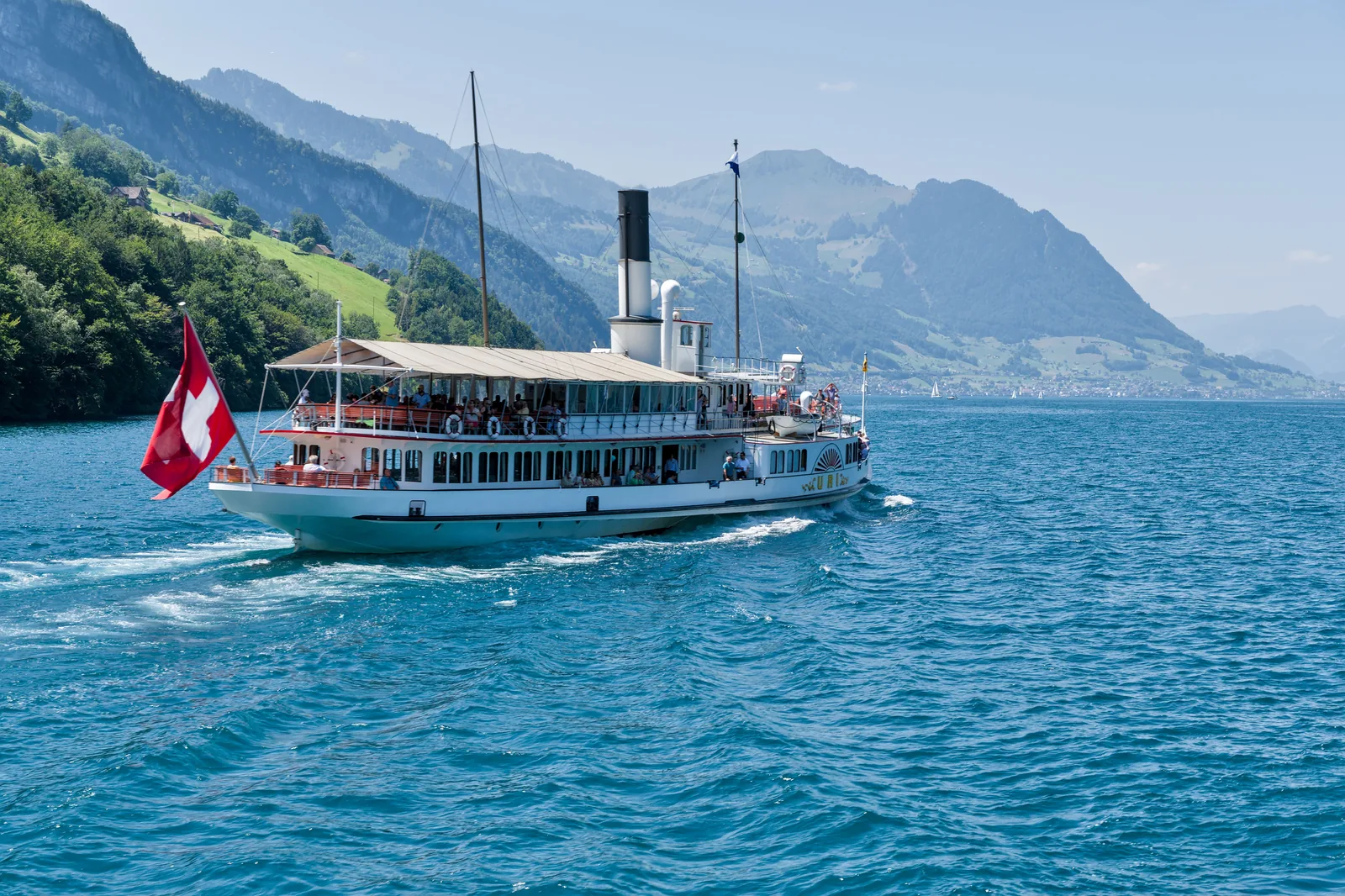 Swiss-flagged passenger boat on a mountain lake