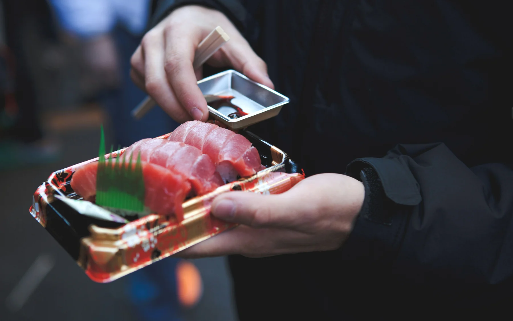Tuna sashimi being sampled at Tsukiji Market in Tokyo