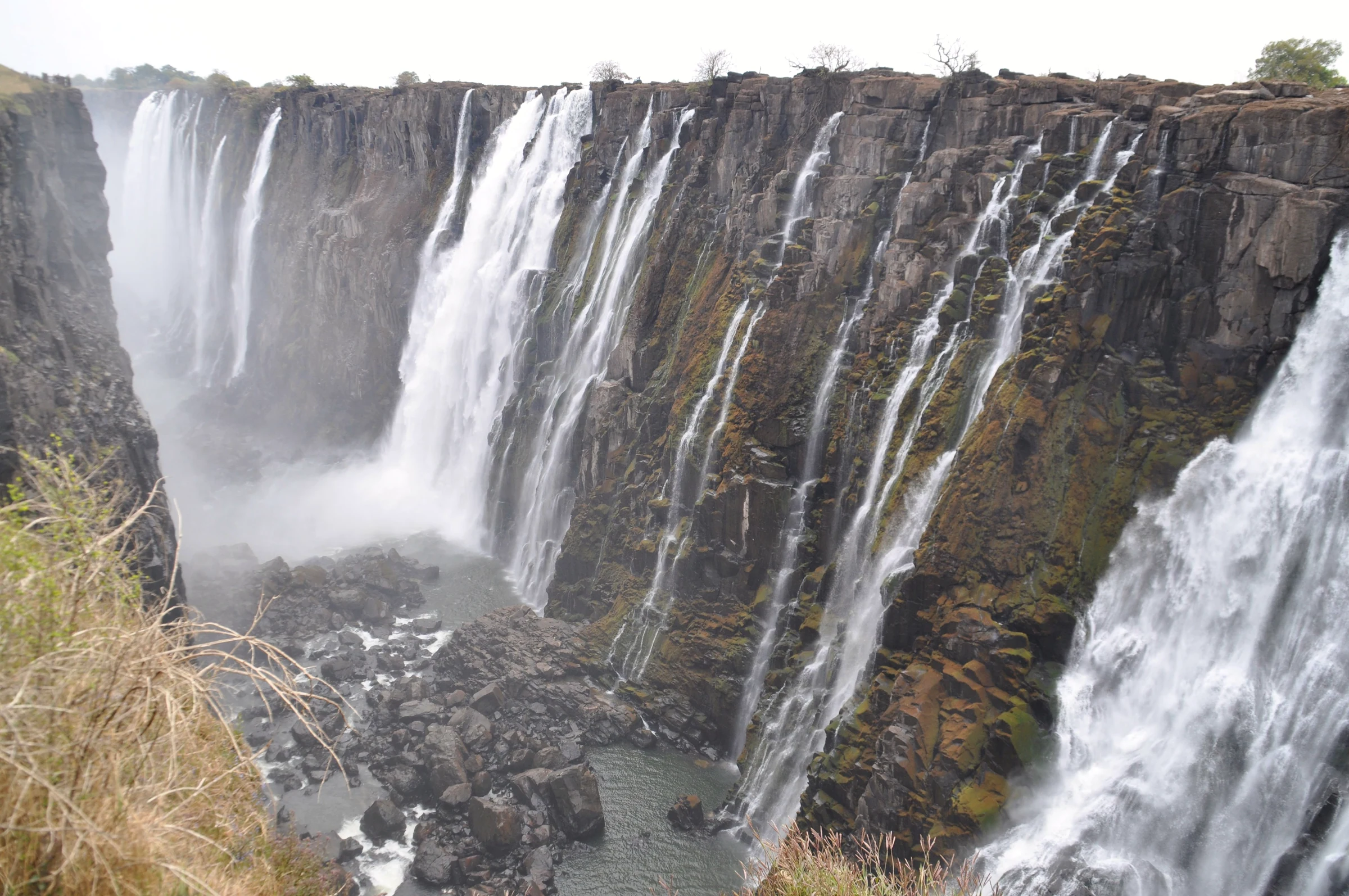 Water cascading over the cliffs at Victoria Falls into a mist-filled gorge