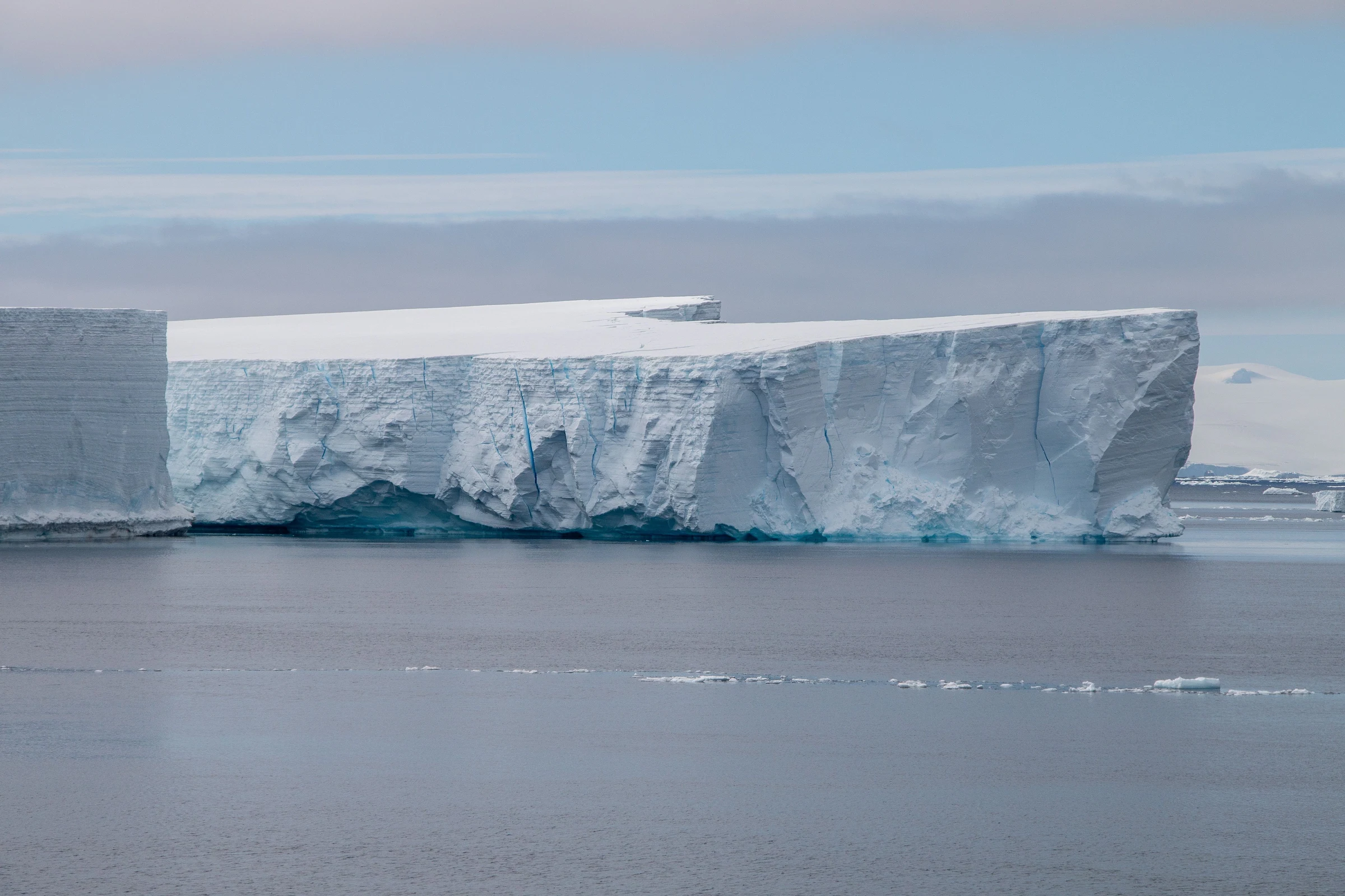 Broad tabular iceberg above calm polar water