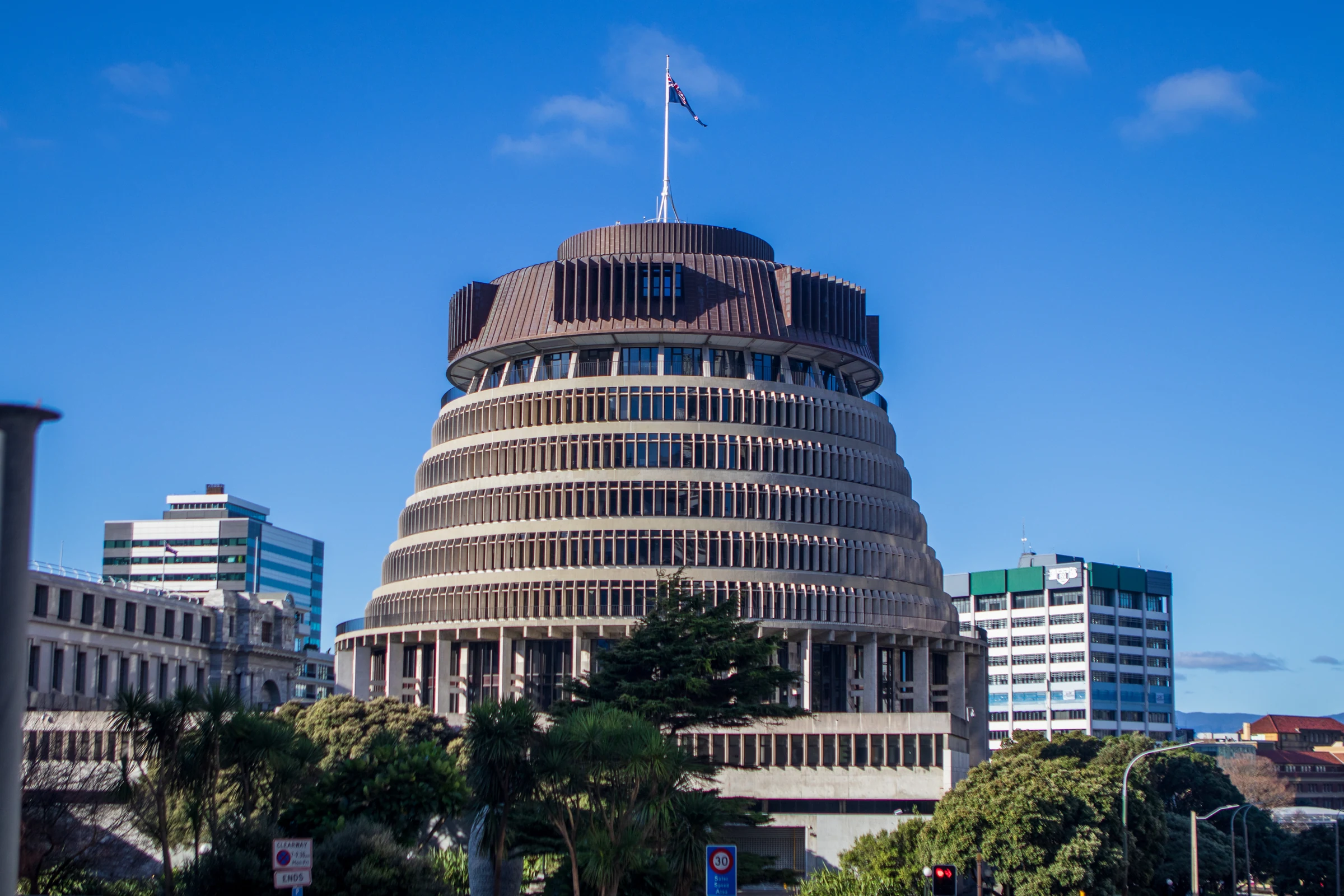 The Beehive Parliament building in Wellington beneath a blue sky