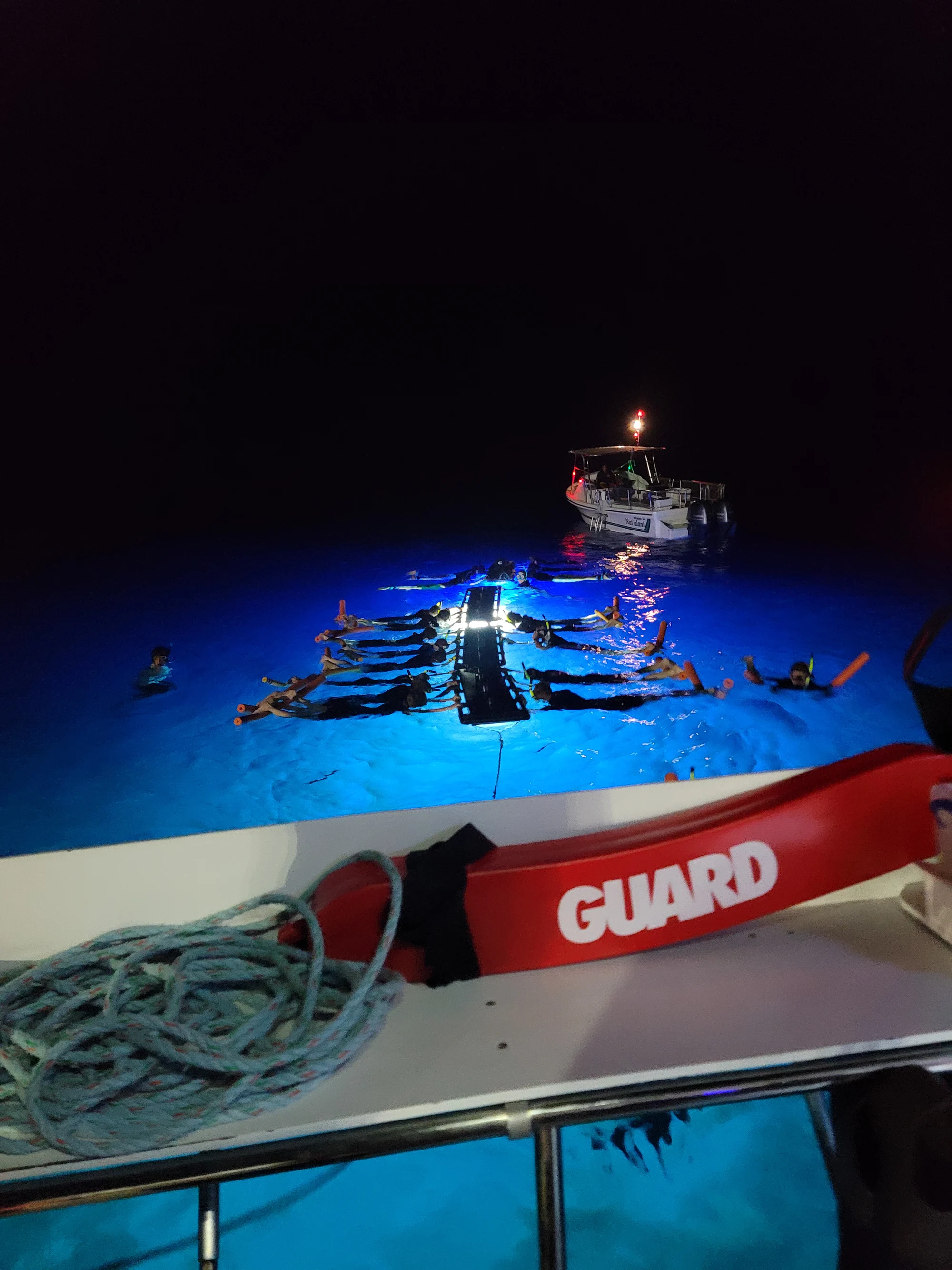 Night snorkelers gathered around illuminated floating boards off Hawaiʻi Island