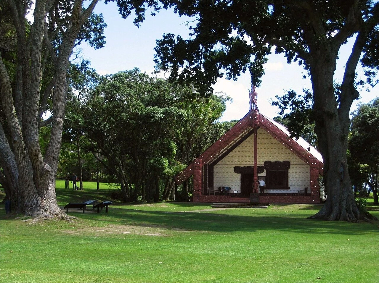 Carved meeting house among trees at the Waitangi Treaty Grounds.