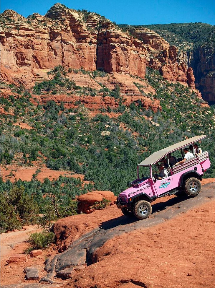 A Pink Jeep Tours vehicle on Sedona red-rock terrain