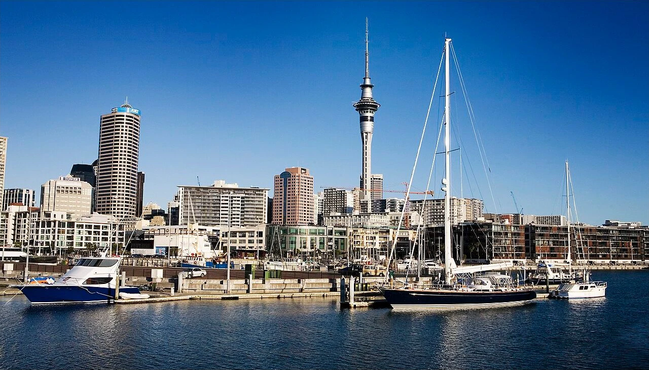 Sailing yachts moored below Auckland’s skyline and Sky Tower.