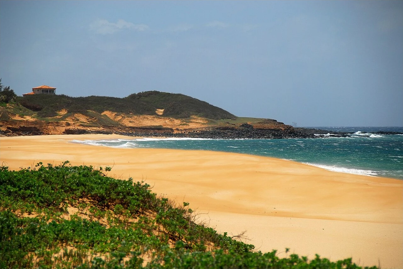 Empty golden sand and blue surf at Papohaku Beach