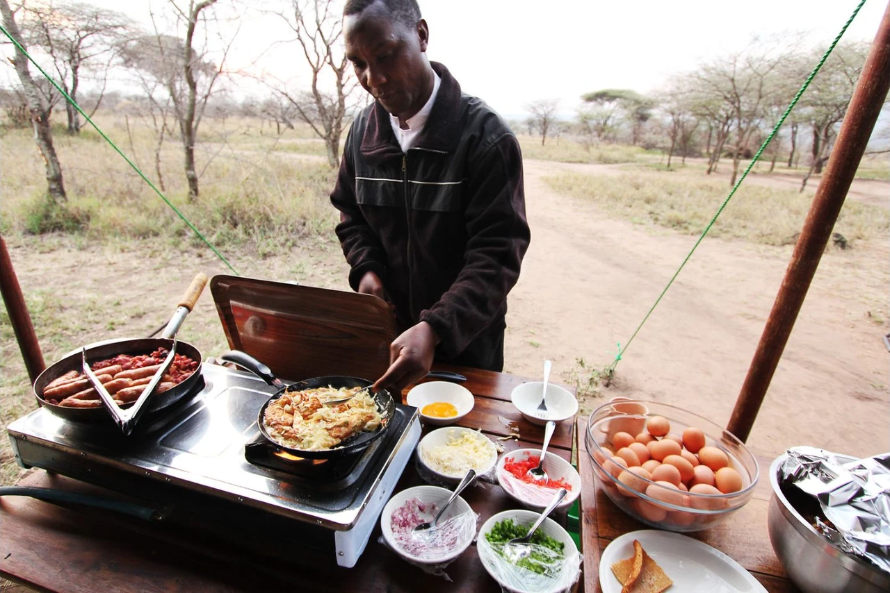 Breakfast being prepared at an outdoor cooking station at Kati Kati Camp in the central Serengeti.
