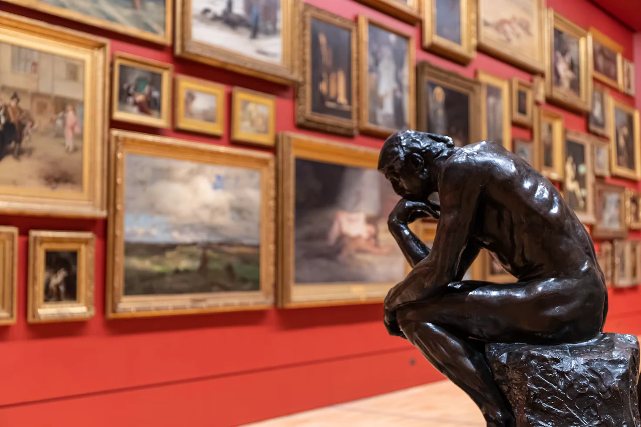 A bronze sculpture and framed paintings in a Melbourne gallery.