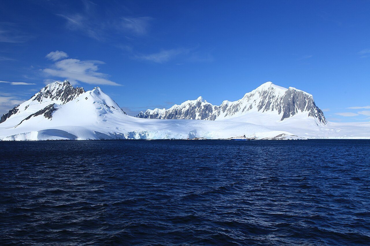 Snow-covered mountains and deep blue water at Port Lockroy, Antarctica
