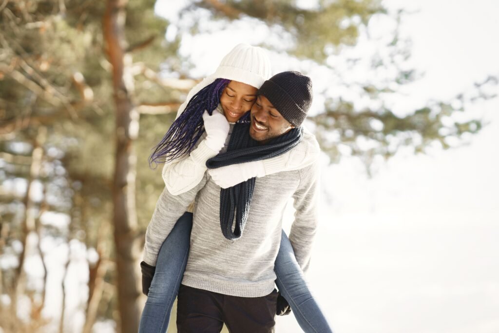 A couple enjoying a piggyback ride in a snowy forest