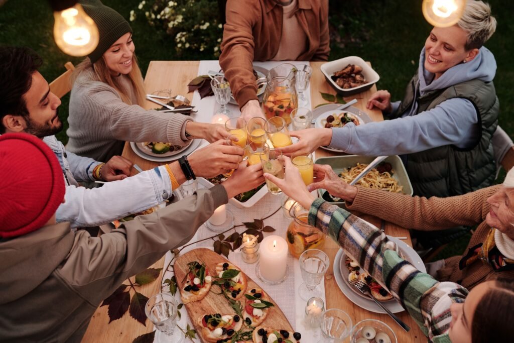 A multigenerational group toasting around an outdoor dinner table