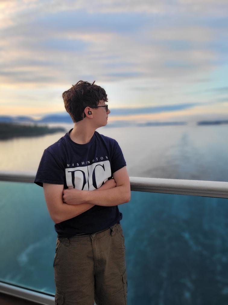 Traveler looking across the water from a cruise ship balcony